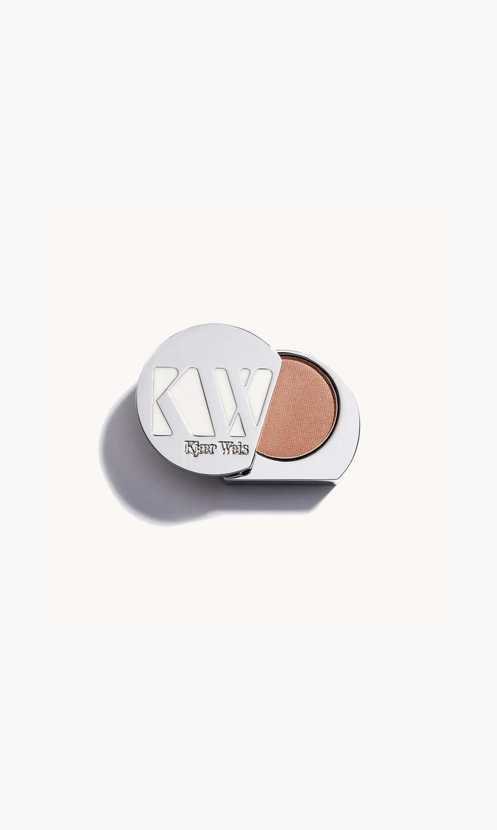 Solid metal KW palette with lid open to show iridescent champagne pink eye shadow inside
